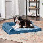Dog resting on a FurHaven Deluxe Chaise orthopedic dog bed in marine blue