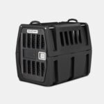 The GUNNER G1™ KENNEL - BLACK is a tough dog crate with sturdy black plastic, a metal mesh door, side ventilation slats, top carrying handles, a secure latch, and reinforced design—ideal for safe pet travel or transport.